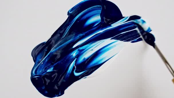Καλλιτέχνης ανάμειξη συστατικά ακουαρέλα χρησιμοποιώντας μαχαίρι παλέτα και χρωστικές ουσίες σε λευκό φόντο. Μπλε ακρυλική μπογιά. Αφηρημένες πινελιές. Εφευρίσκει νέα χρώματα. Καμβάς υφή. Βούρτσα. — Αρχείο Βίντεο