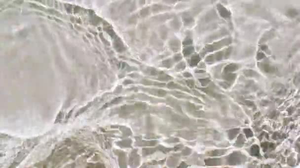 Pure beige water with reflections sunlight in slow motion. Water surface texture top view. Sun and shadows. Motion clean swimming pool ripples and wave. — Stock Video