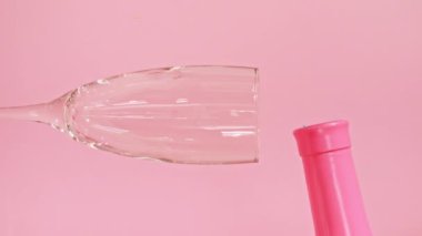 Renkli şekerler, pembe arka planda şarap bardağına dökülen şekerlemeler. Tatil konsepti, doğum günü partisi, Noel, Yeni Yıl.