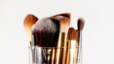 Makyaj fırçaları beyaz arka planda döner. Profesyonel Makyaj ve Güzellik. Dekoratif kozmetik. Yakın plan.