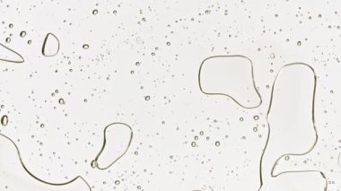 Gümüş renkli arka planda köpük içeren şeffaf kozmetik jel sıvısı. Makro Vuruş