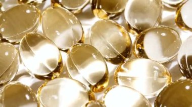 Sarı kapsüller tıbbi haplar, yakın çekim dönüşümlü. C vitamini, Omega 3 yağ kapsüllerinde. Haplar ve uyuşturucular. İlaç Endüstrisi. Tıp konsepti. Yavaş çekim