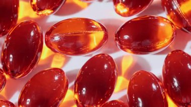 Kırmızı yağ kapsüllerinin makro görüntüsü, C vitamini, Omega 3 yakın çekim. Haplar ve uyuşturucular. İlaç Endüstrisi. Tıp konsepti. Yavaş çekim