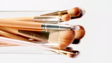 Makyaj fırçaları beyaz arka planda döner. Profesyonel Makyaj ve Güzellik. Dekoratif kozmetik. Yakın plan.