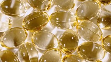 Sarı yağ kapsüllerinin makro görüntüsü, C vitamini, Omega 3, yakın çekim. Haplar ve uyuşturucular. İlaç Endüstrisi. Tıp konsepti. Yavaş çekim