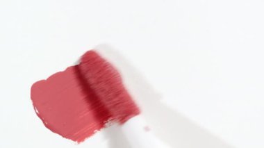 Kozmetik sıvı dudak parlatıcısı, ruj lekesi, leke, felç. Fırça, aplikatör dudak parlatıcısı beyaz arka planda izole edilmiş lekeler. Profesyonel kozmetik reklamları..