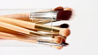 Makyaj fırçaları beyaz arka planda döner. Profesyonel Makyaj ve Güzellik. Dekoratif kozmetik. Yakın plan.