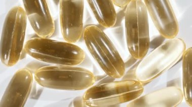 Sarı yağ kapsüllerinin makro görüntüsü, C vitamini, Omega 3, yakın çekim. Haplar ve uyuşturucular. İlaç Endüstrisi. Tıp konsepti. Yavaş çekim