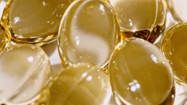 Sarı yağ kapsüllerinin makro görüntüsü, C vitamini, Omega 3, yakın çekim. Haplar ve uyuşturucular. İlaç Endüstrisi. Tıp konsepti. Yavaş çekim