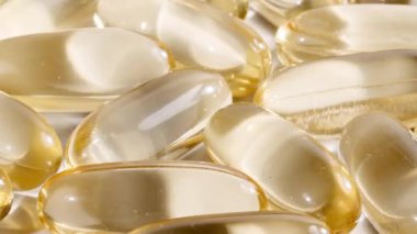 Sarı yağ kapsüllerinin makro görüntüsü, C vitamini, Omega 3, yakın çekim. Haplar ve uyuşturucular. İlaç Endüstrisi. Tıp konsepti. Yavaş çekim