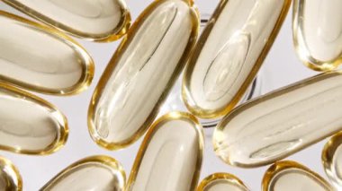 Sarı yağ kapsüllerinin makro görüntüsü, C vitamini, Omega 3, yakın çekim. Haplar ve uyuşturucular. İlaç Endüstrisi. Tıp konsepti. Yavaş çekim