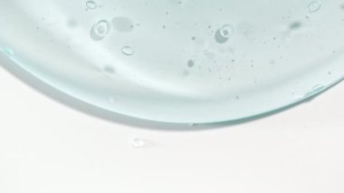 Şeffaf Mavi Kozmetik Sıvı Jel 'in Macro Shot' u, Beyaz bir yüzeye dökülen köpüklü Krem. Doğal Organik Kozmetik, Tıp.