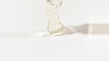 Sıvı sarı jel ya da beyaz bir yüzeye damlayan pipette serum. Yukarıdan köpüklü kozmetik sıvısı için damlatıcı.