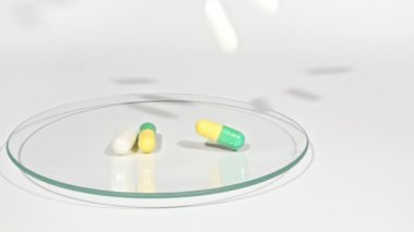 Beyaz arka planda Petri kabının üzerine düşen farklı tıbbi hapların yakın çekimi. Kapsüller, vitaminler ve ilaçlar. İlaç Endüstrisi. Tıp konsepti. Makro atış. Yavaş çekim