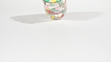 Beyaz arka plandaki masaya düşen farklı tıbbi ilaçların yakın çekimi. Kapsüller, vitaminler ve ilaçlar. İlaç Endüstrisi. Tıp konsepti. Makro atış. Yavaş çekim