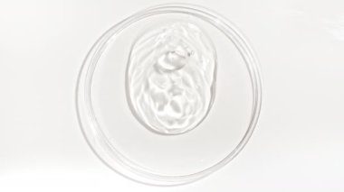 Şeffaf Kozmetik Sıvı Petri 'nin cam kasesine damlıyor. Makro Kozmetik Serumu, Hyalurinik asit. Cilt Bakımını Göster.