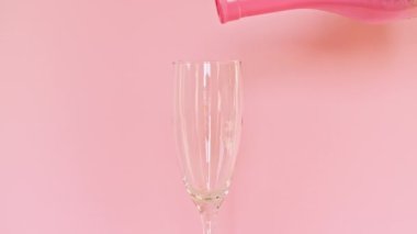 Renkli şekerler, pembe arka planda şarap bardağına dökülen şekerlemeler. Tatil konsepti, doğum günü partisi, Noel, Yeni Yıl.