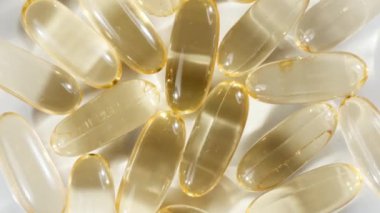 Sarı yağ kapsüllerinin makro görüntüsü, C vitamini, Omega 3, yakın çekim. Haplar ve uyuşturucular. İlaç Endüstrisi. Tıp konsepti. Yavaş çekim