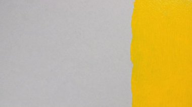 Gri arka planda sarı akrilik boya. Soyut sarı suluboya fırça darbeleri. Çadır bezi. Boya fırçası, silindir. Akrilik lekeleme ayarlandı.