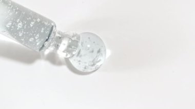 Sıvı mavi jel ya da beyaz bir yüzeye damlayan pipette serum. Yukarıdan köpüklü kozmetik sıvısı için damlatıcı.