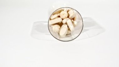 Beyaz arka plandaki masaya düşen farklı tıbbi ilaçların yakın çekimi. Kapsüller, vitaminler ve ilaçlar. İlaç Endüstrisi. Tıp konsepti. Makro atış. Yavaş çekim