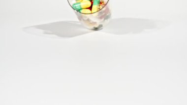 Beyaz arka plandaki masaya düşen farklı tıbbi ilaçların yakın çekimi. Kapsüller, vitaminler ve ilaçlar. İlaç Endüstrisi. Tıp konsepti. Makro atış. Yavaş çekim