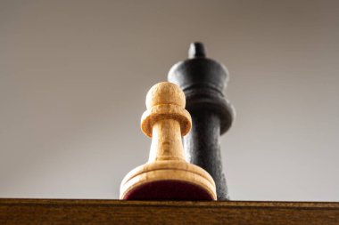 Satranç tahtasında beyaz piyon ve siyah papaz.