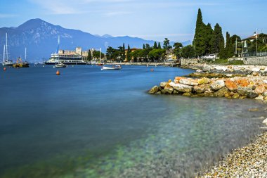 Garda Gölü, Malcesine, Verona, İtalya 'da limandaki bir körfez ve turistik teknenin manzarası
