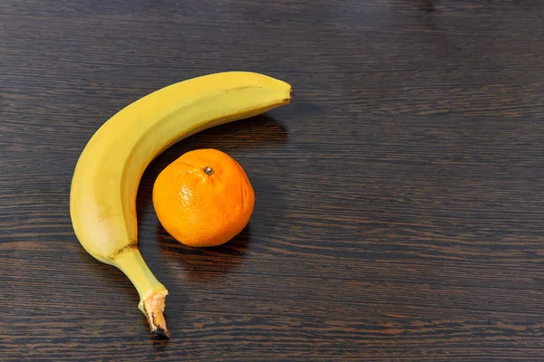 Muz ve mandalina, açık renkli arka planda parlak meyveler..