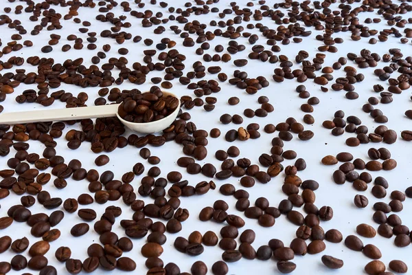 Kahve çekirdekleri ve arka planda plastik kaşık..