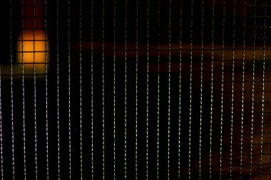 Karanlıkta metal örgü. Geceleri ızgaranın dokusunu. Çitlerden yapılma. Kare tel örgü.