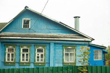 Rusya 'daki kır evi. Mavi ahşap ev. Kırsal yaşam. Rus mimarisi. Tarihi bir evde eski pencereler.