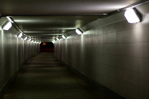 Lighting in the tunnel. Pedestrian crossing with lamps. LED light in a long tunnel under the track. Urban transport infrastructure.