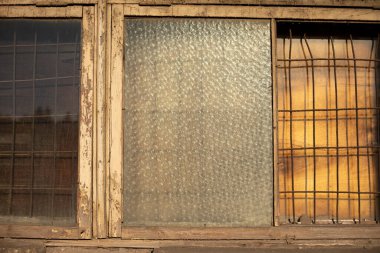 Ahşap çerçevedeki eski cam. Binanın penceresi. Pencerenin açılışında aşınmış boya..
