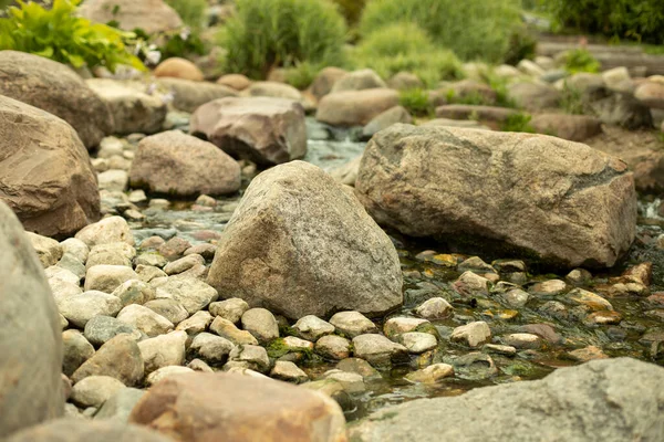 公園の景観デザインの石 渓流の中の石畳 滝と人工池 水が流れる石がたくさんあります — ストック写真