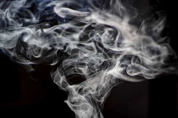 Smoke in natural light. Tobacco smoke fills the air. Clubs of steam in space. The process of smoke in the room.