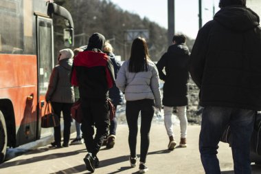 İnsanlar otobüse biniyor. Bir sürü insan otobüs için kuyruğa giriyor. Şehirde toplu taşıma. İnsanlar gemiye binmek için bekliyor..