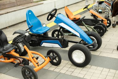 Çocuk nakil aracı parkta. Mekanik rotadaki makineler. Kiralık bisikletleri eğlendiriyorum. Anaokulu öğrencileri için scooterlar.