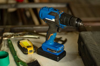 Masada tornavida var. Garajda elektrikli alet var. Akümülatörlü elektrikli tornavida. Çalışan alet. Erkek eğilimi.