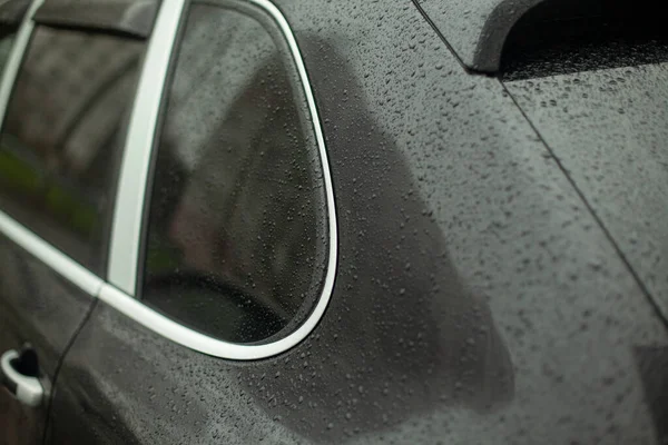 扔在车上 汽车零部件在雨中 黑色表面上的小滴 运输容易受风化的影响 — 图库照片