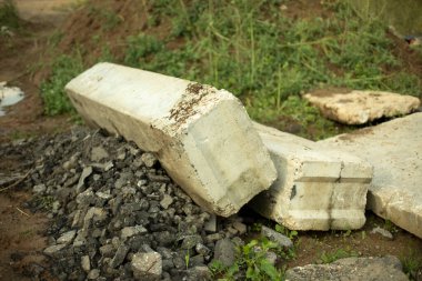 Beton yapı parçaları yerde yatıyordu. Kaba maddenin yapısı gri. Rusya 'da inşaat. Dışarıda ateş ediyorlar.