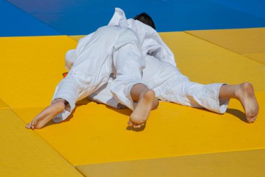 Karate yarışması. Çocuk kavgası. Sporcular tatamide kavga eder. Çocuklar için güreş dersi. Öğrenciler arasındaki rekabet.