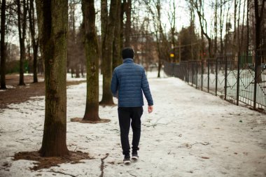 Adam bir çıkış yolu arıyor. Bir adam parkta yürüyor. Kışın insan.