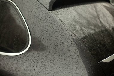 Arabanın üzerine düşüyor. Araba parçaları yağmurda. Siyah bir yüzeye küçük damlalar. Nakliye aracı hava şartlarına maruz kaldı..