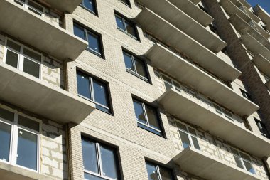 Yeni bina. Moskova 'da bir apartman inşaatı. Güneş ışığı altında bir ev. Eve plastik pencereler yerleştirdim. Tamamlanmamış yapı.