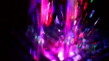 Colored stream of water on dark background. Fountain at night. Jet of water rises up in turbulent stream. Illumination of fountain at night. Video shooting of monotonous movement of liquid.