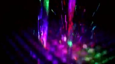 Colored stream of water on dark background. Fountain at night. Jet of water rises up in turbulent stream. Illumination of fountain at night. Video shooting of monotonous movement of liquid.