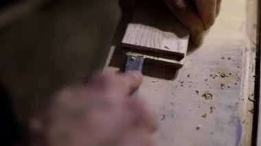 Marangoz temizlik yapıyor. El aletleri. Kesme açısı. Ahşap işleme. Elinde keskin bir bıçak..