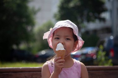Bir çocuk dondurma yer. Kız tatlılığı ısırıyor. Çocuğun elinde yaz dondurması. Panama 'da bir anaokulu öğrencisi. Yazın sokakta dinlenin..
