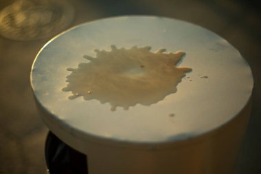 Kahve birikintisi. Dökülmüş içki. Su yüzeyde. Sıvı damlası. Noktanın yayılması.